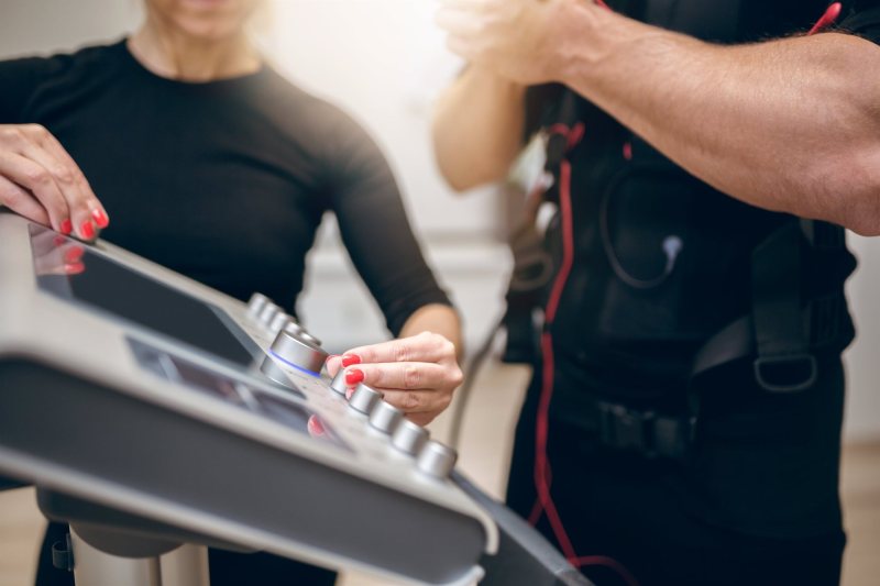 Cropped portrait of trainer hands turning on ems device